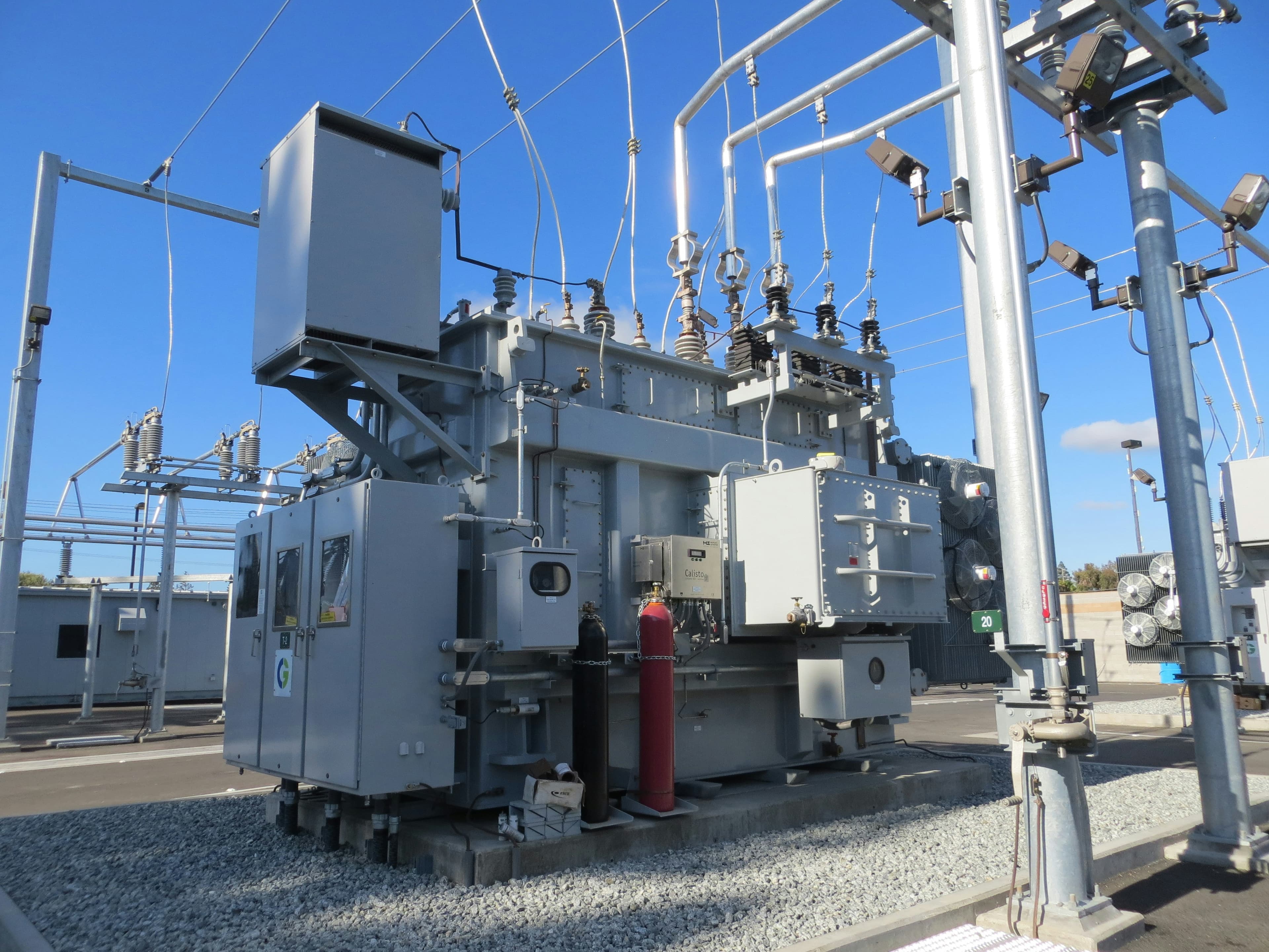 High-voltage electrical substation with transformers and switchgear.